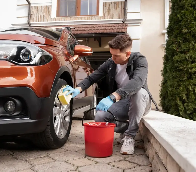 Lavage auto à domicile Les Essards-Taignevaux : professionnel intervenant sur un véhicule